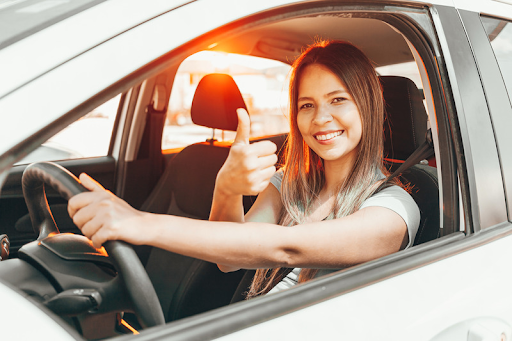 Happy car owner looking at camera showing thumbs up