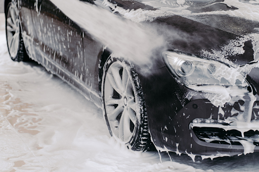 Black car being shampooed at a touchless carwash